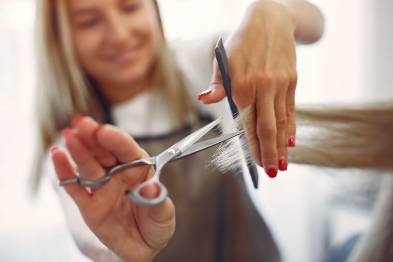 Hairdresser cut hair her client. Woman in a hair salon